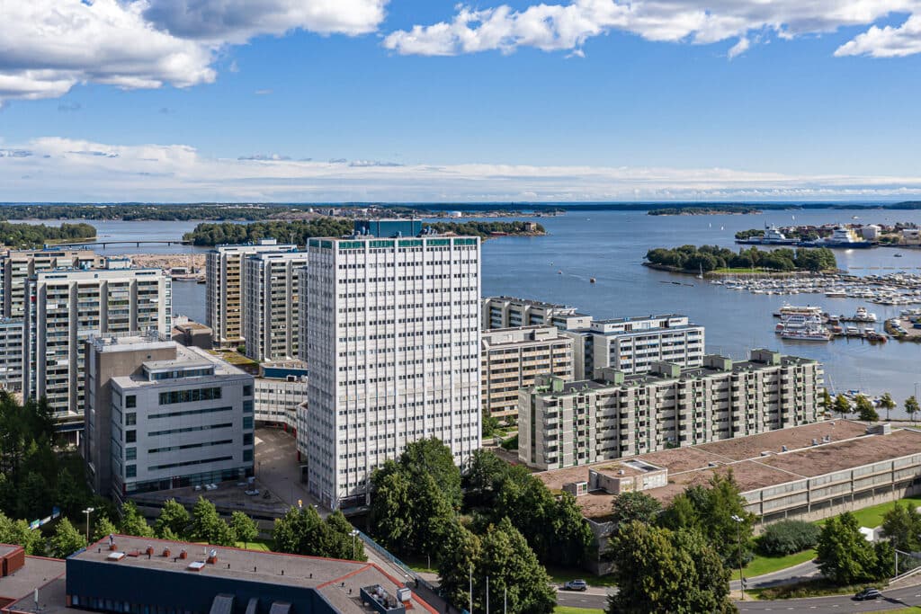 Kiinteistö kuvattuna ilmasta. Useita rakennuksia joista Meritorni korkein. Takana näkyy merta.
